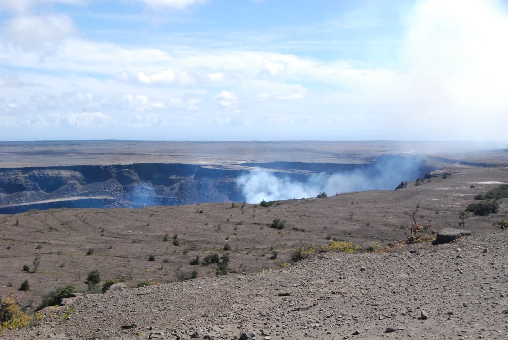 a view of a large open area with a lake in the distance