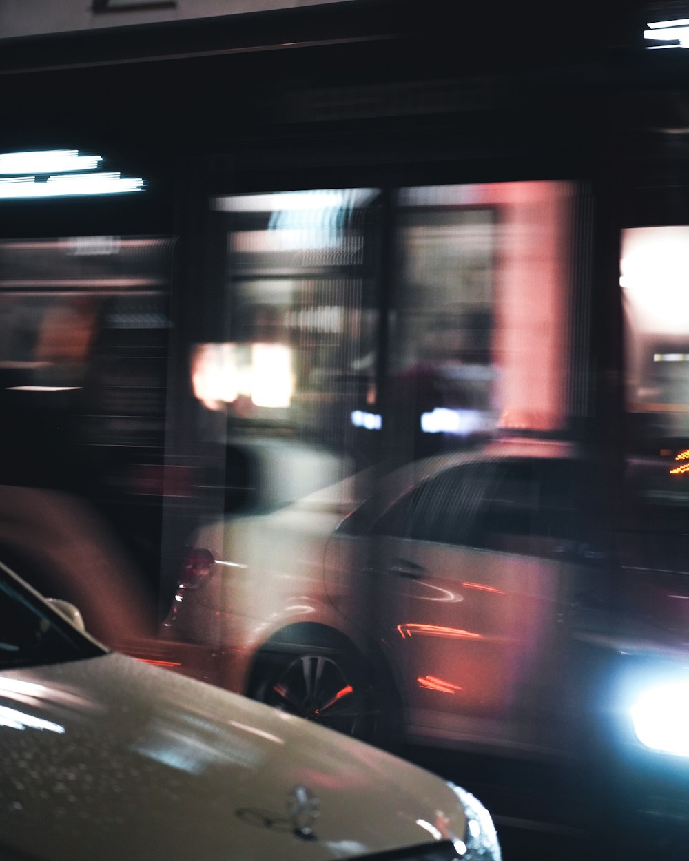 a blurry photo of a car and a bus at night