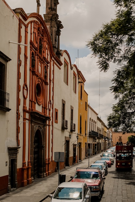 a row of parked cars in front of a tall building