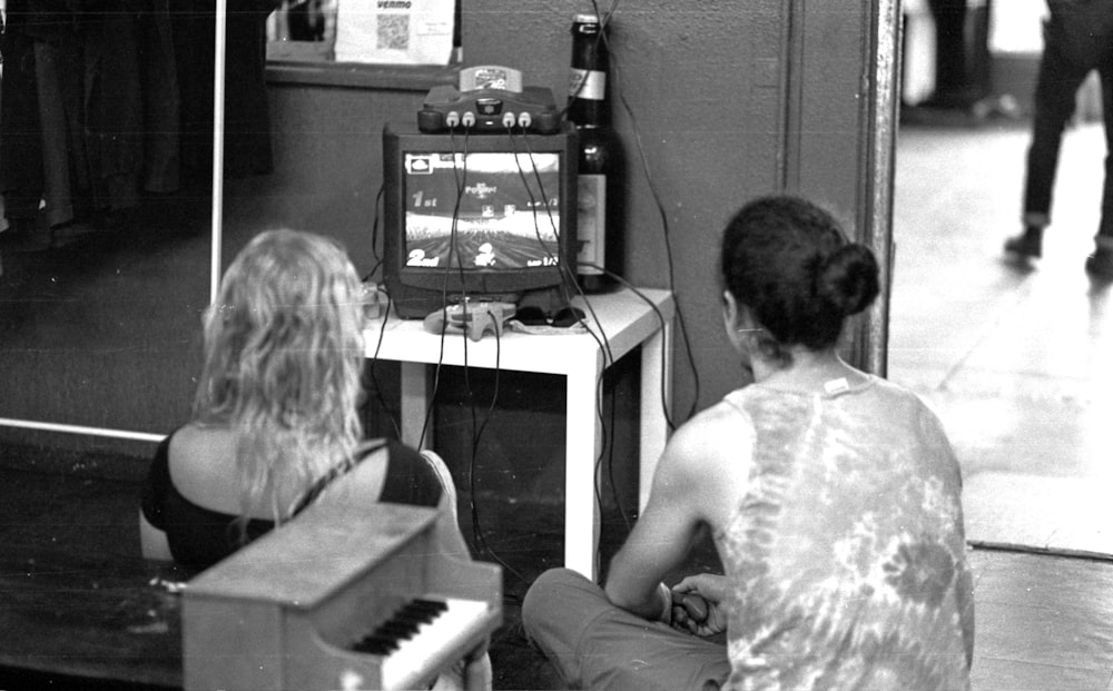 a couple of people sitting in front of a tv