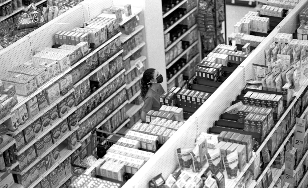 Ein Schwarz-Weiß-Foto einer Frau, die in einem Lebensmittelgeschäft einkauft