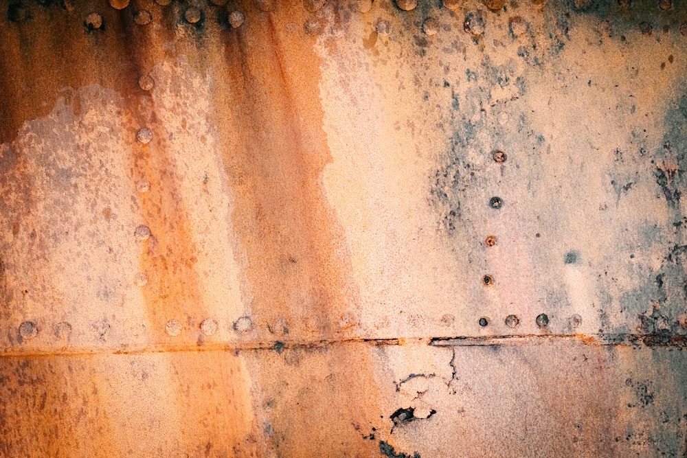 a rusted metal surface with rivets and rivet holes