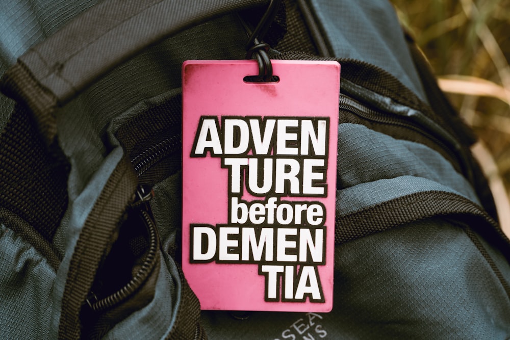 a pink tag that says, adventure before demmen tia