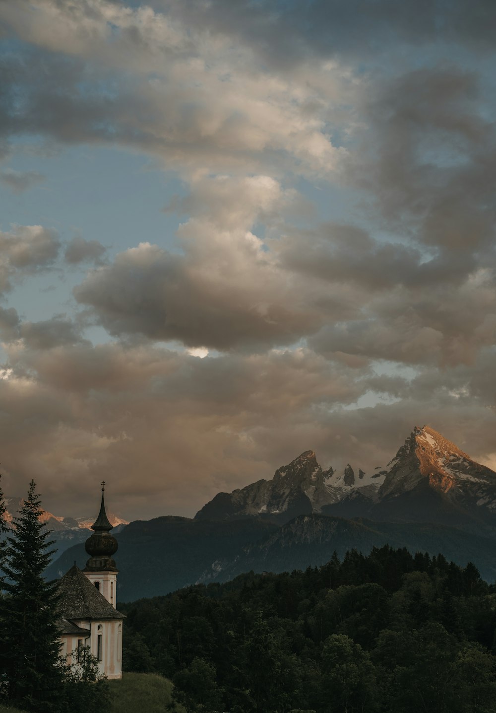 a church in the foreground with a mountain in the background
