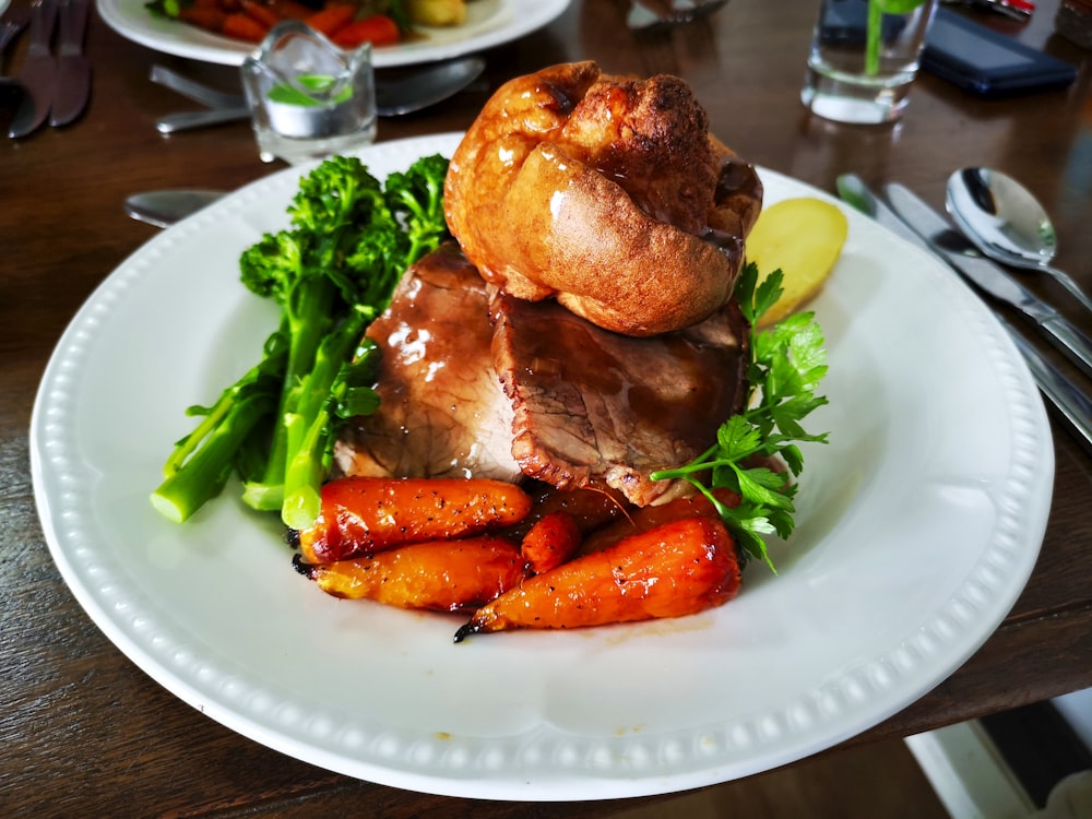 a white plate topped with meat and veggies