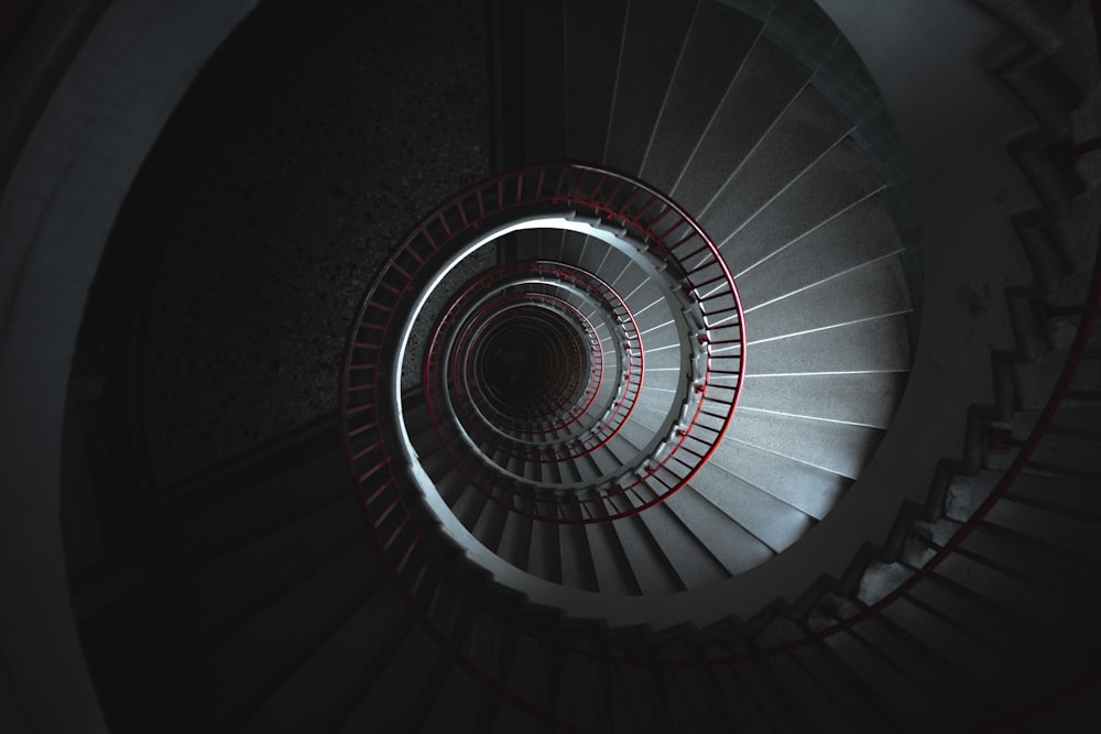 a spiral staircase in a building with red lights