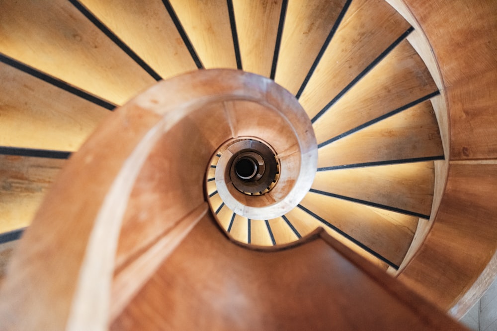 a wooden spiral staircase with a light at the top