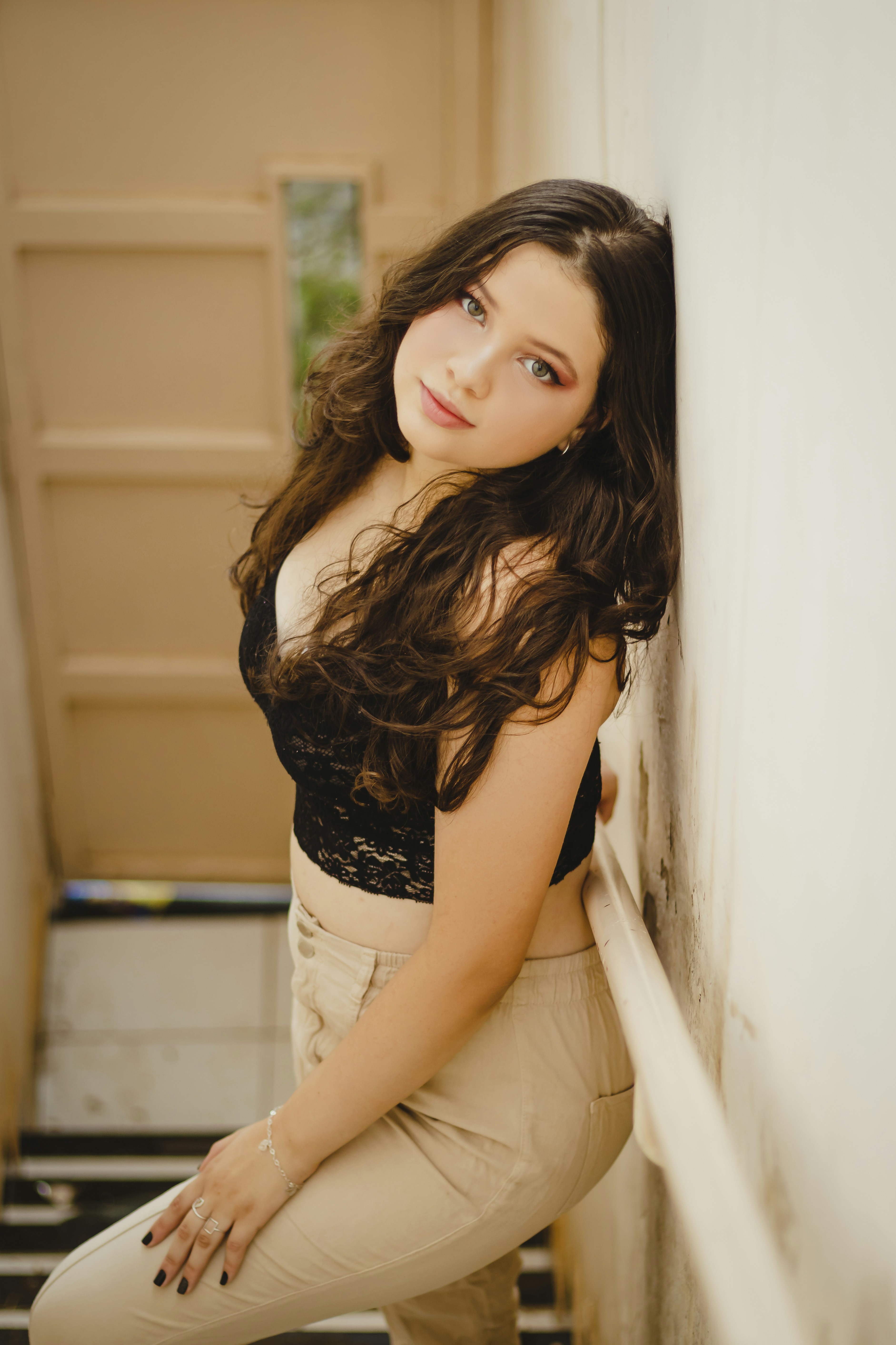 A beautiful young woman leaning against a wall photo pic