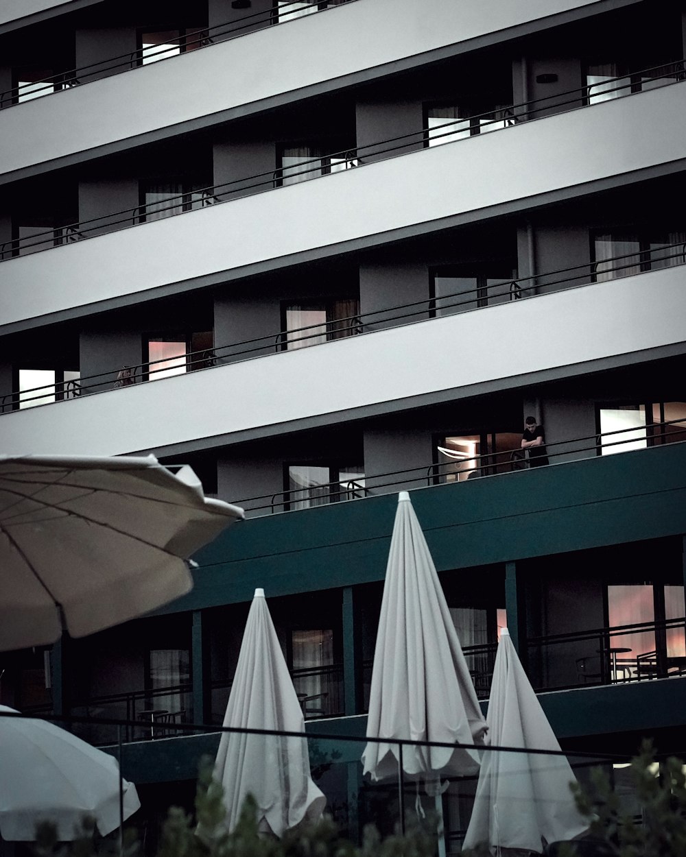 a group of white umbrellas sitting in front of a building