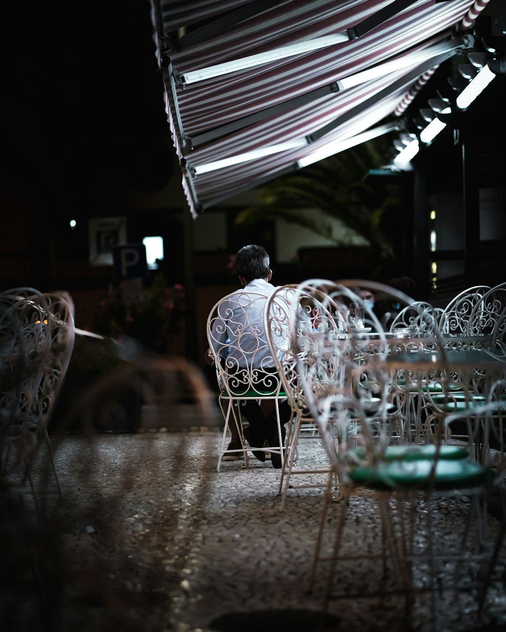 a person sitting at a table under an umbrella