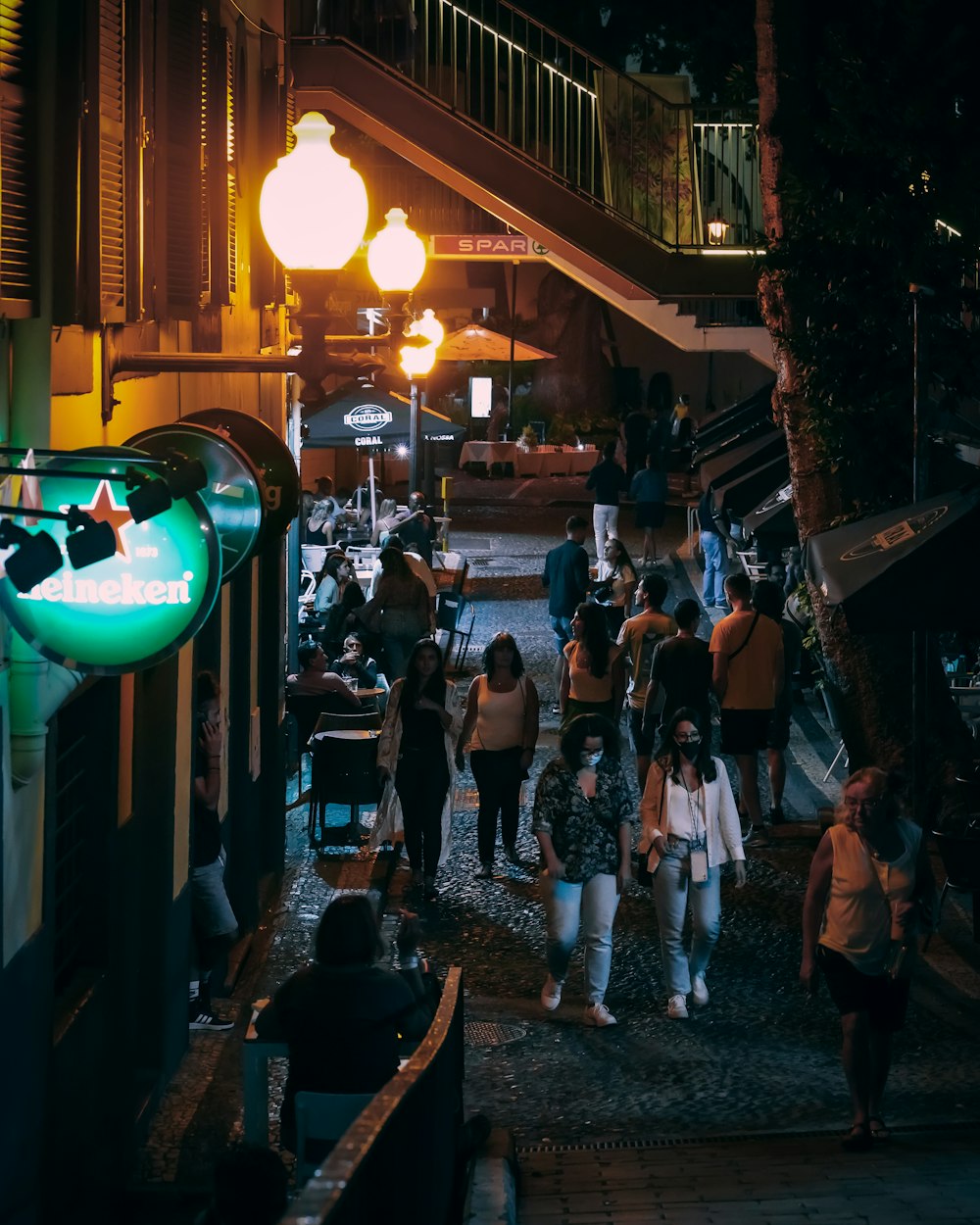 a group of people walking down a street at night