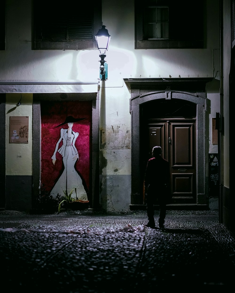 a person standing in front of a doorway at night