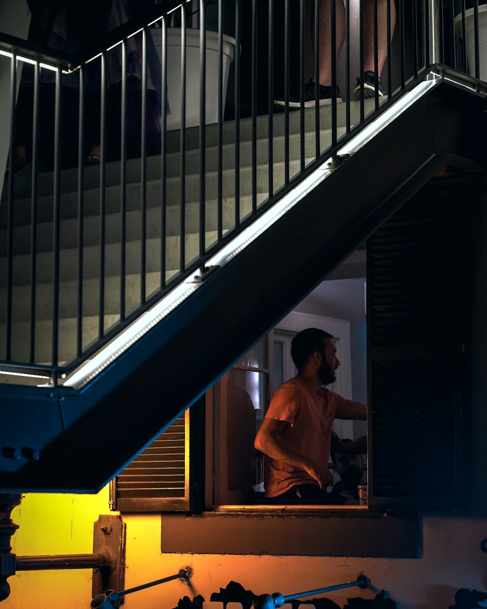 a man standing in a doorway next to a stair case