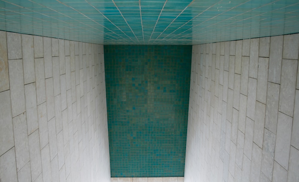 a white toilet sitting in a bathroom next to a tiled wall