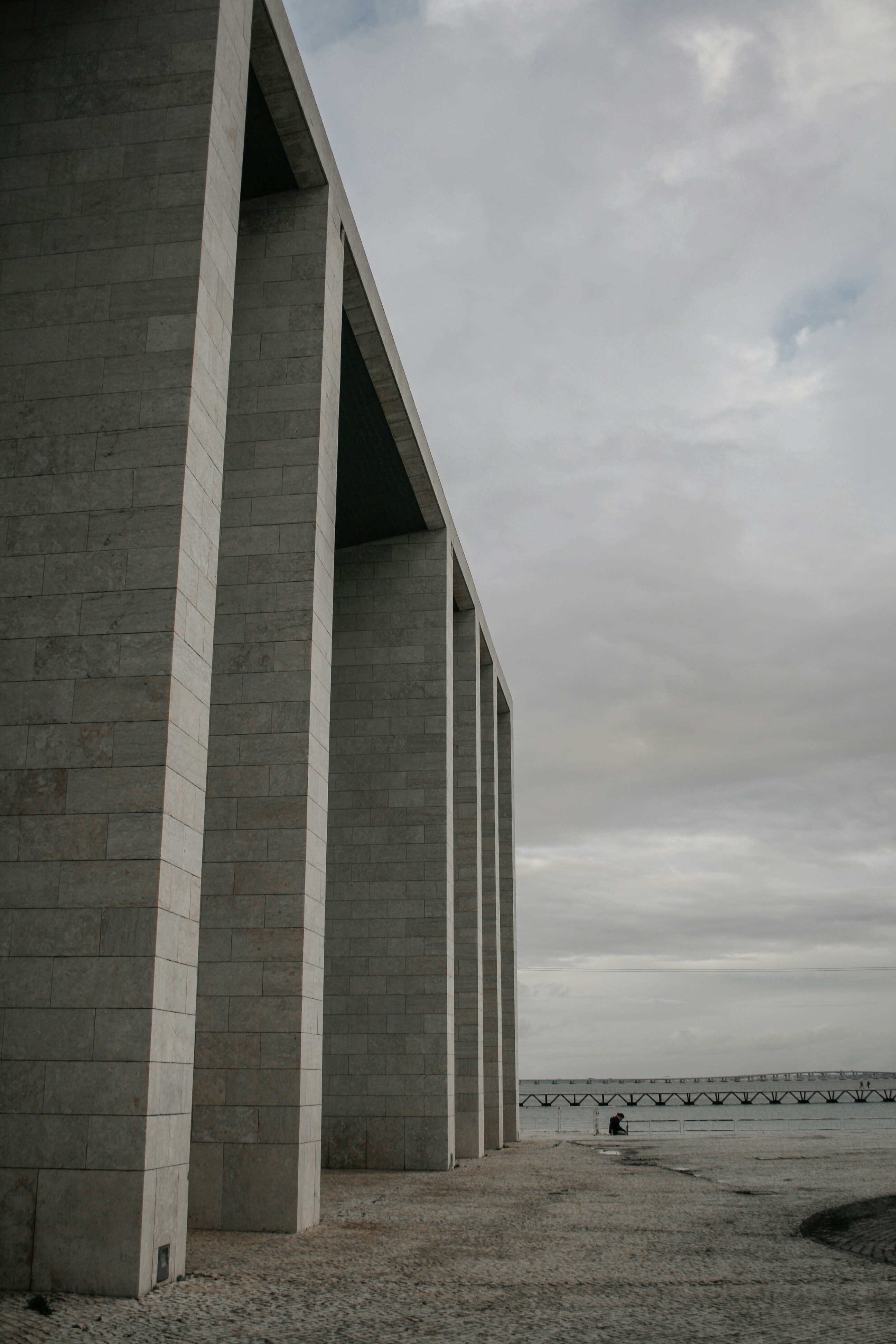 a person sitting on a bench next to a building