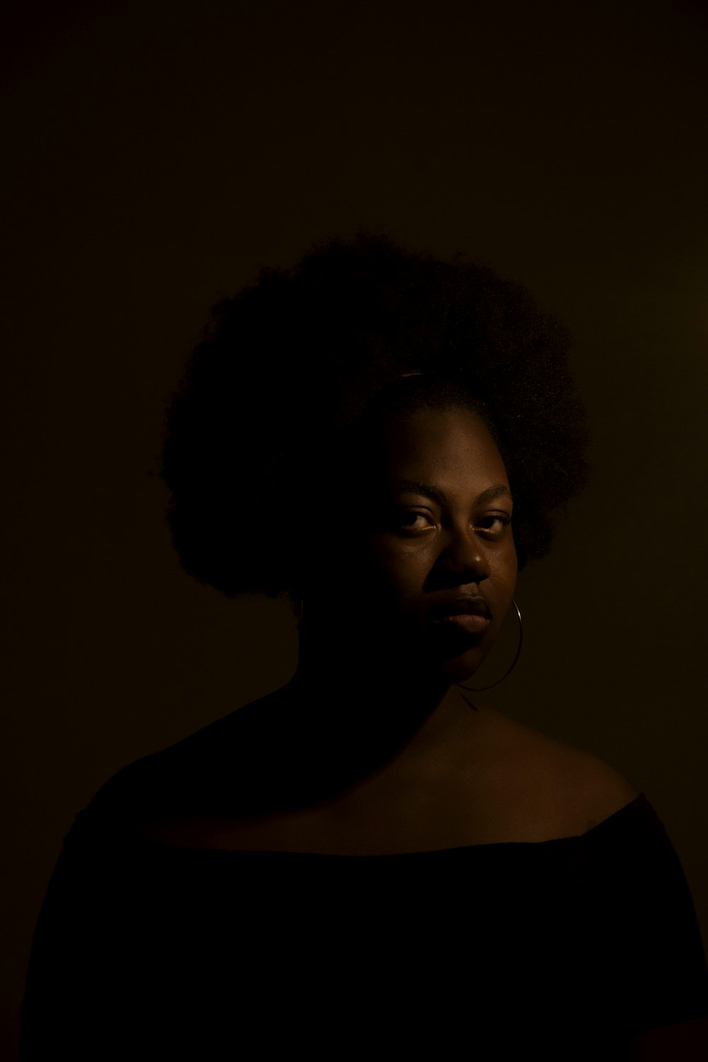 a woman standing in a dark room with her eyes closed