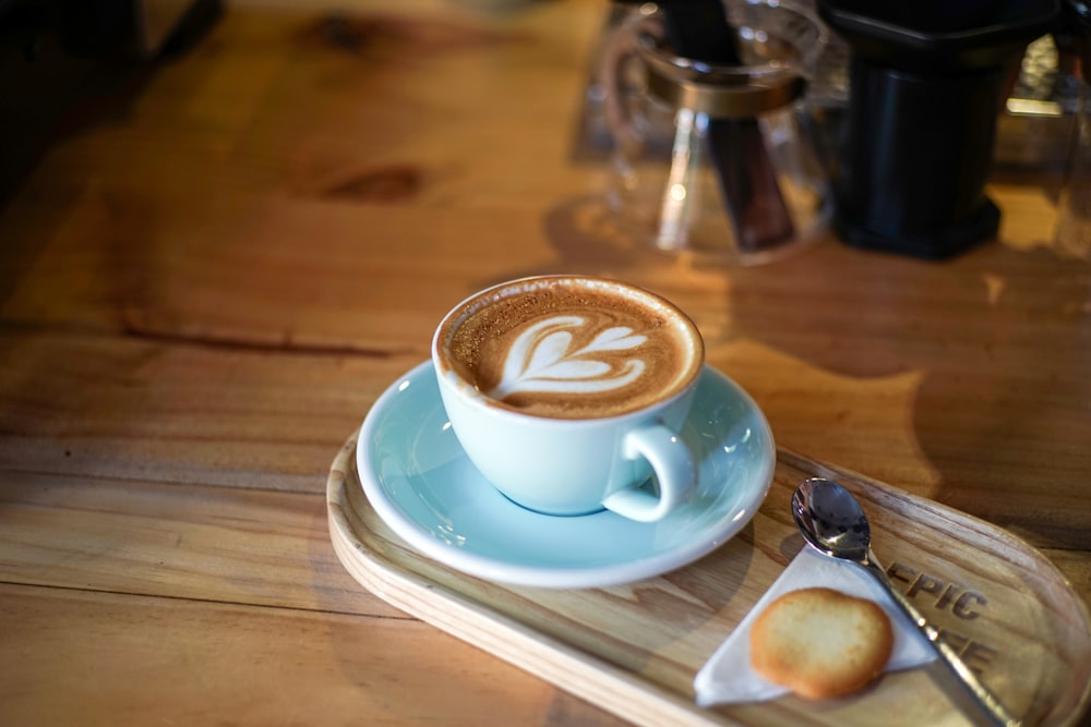 a cup of cappuccino on a wooden tray