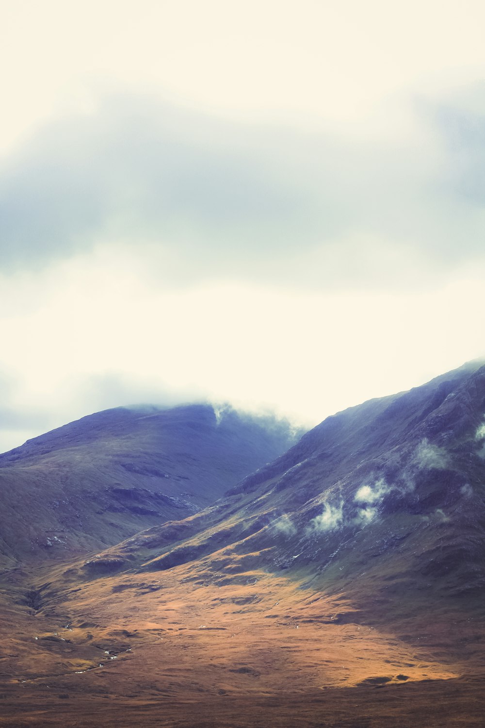 a mountain range with a few clouds in the sky