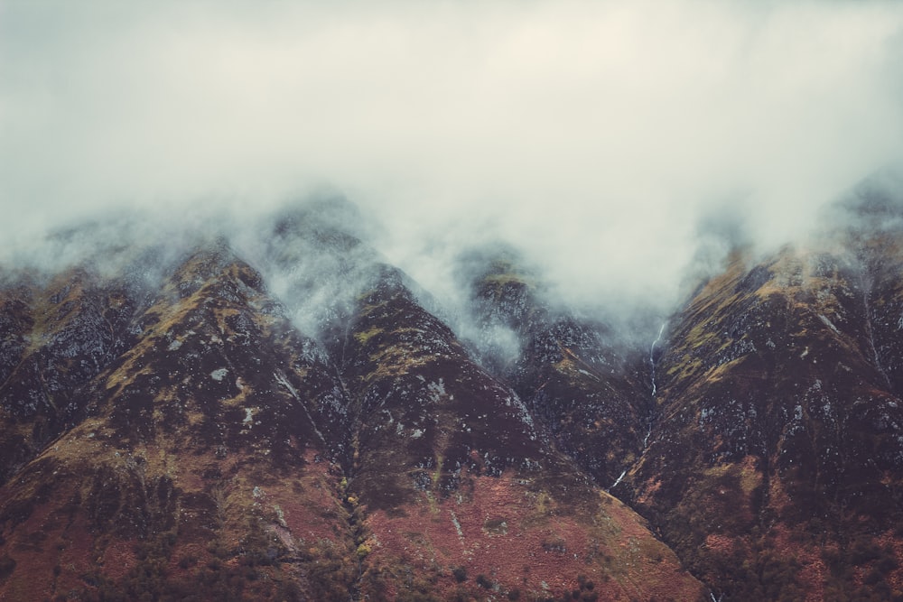 a mountain range covered in snow and clouds