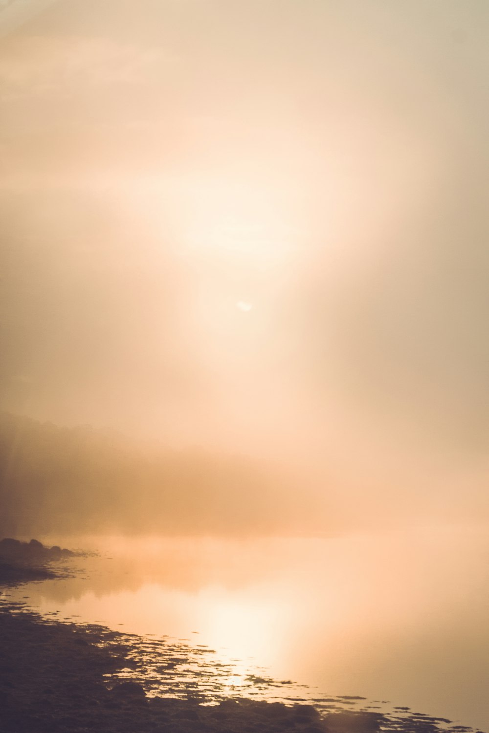 a person standing on a beach next to a body of water