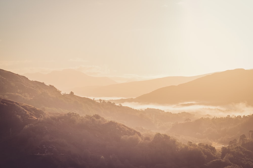 uma vista de um vale com montanhas ao fundo