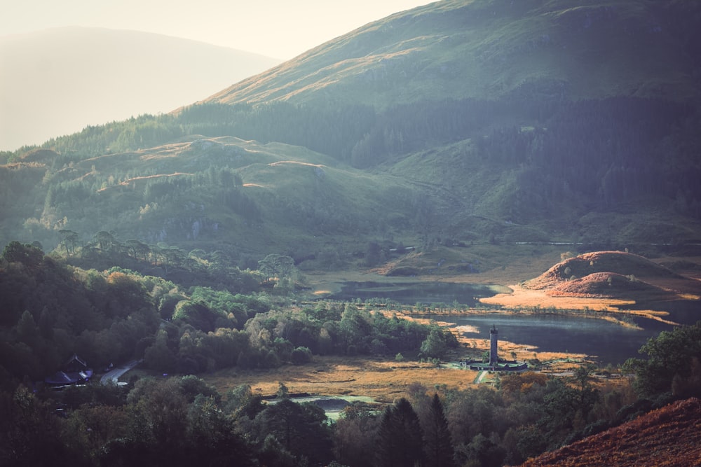 a scenic view of a valley with a mountain in the background