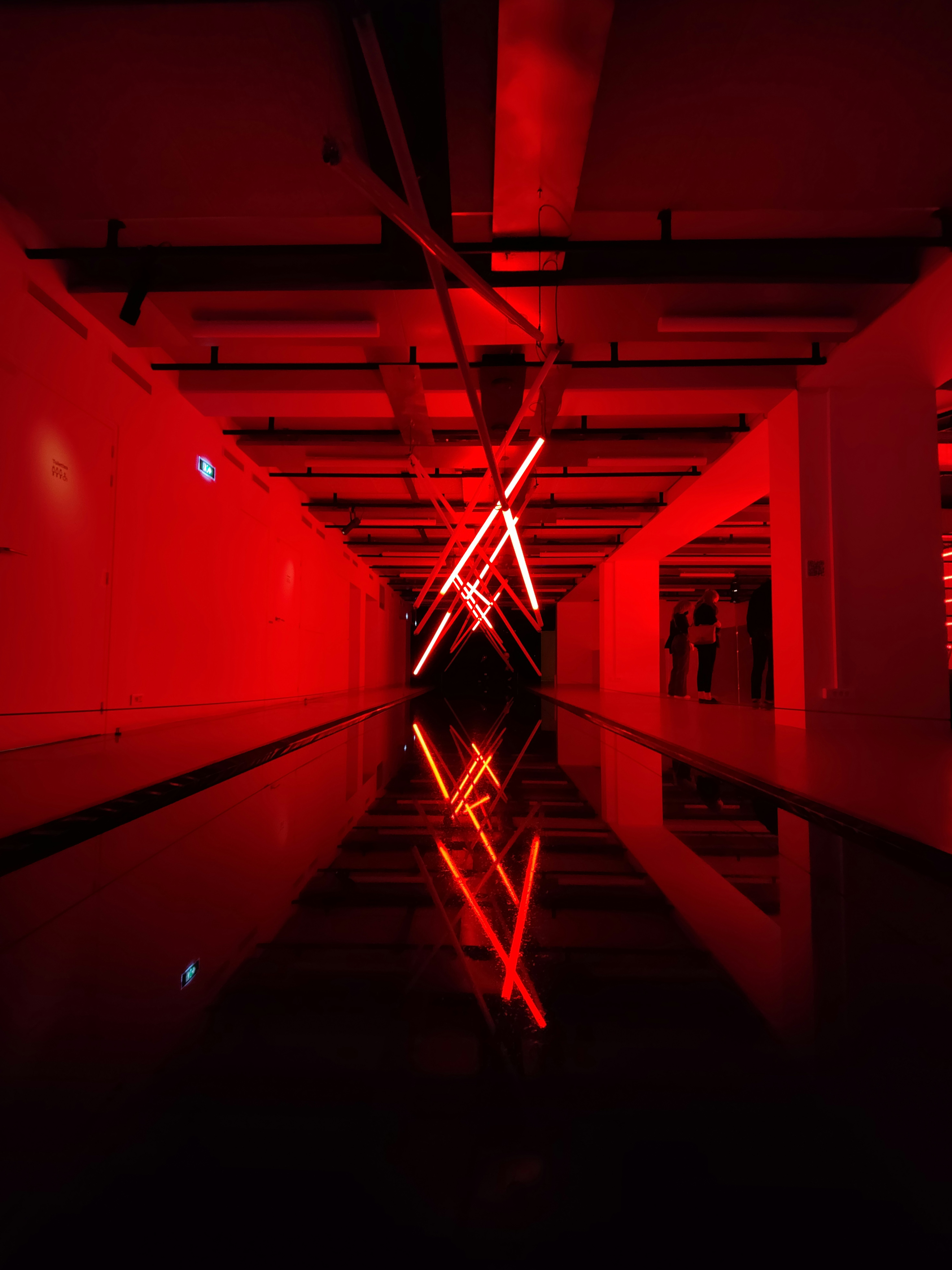 a long hallway with a red light in the middle of it