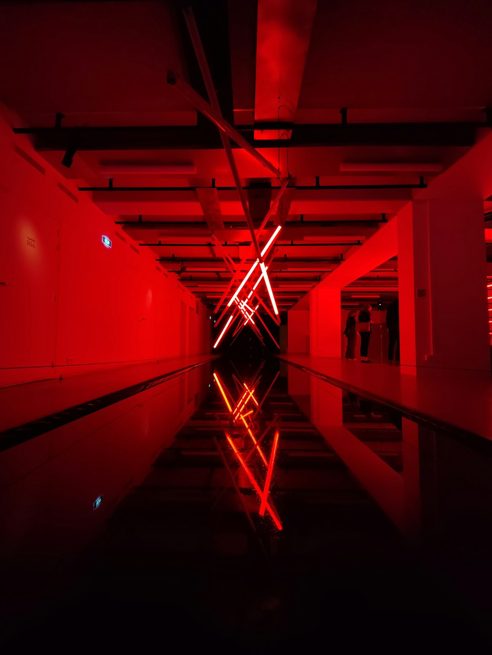 a long hallway with a red light in the middle of it