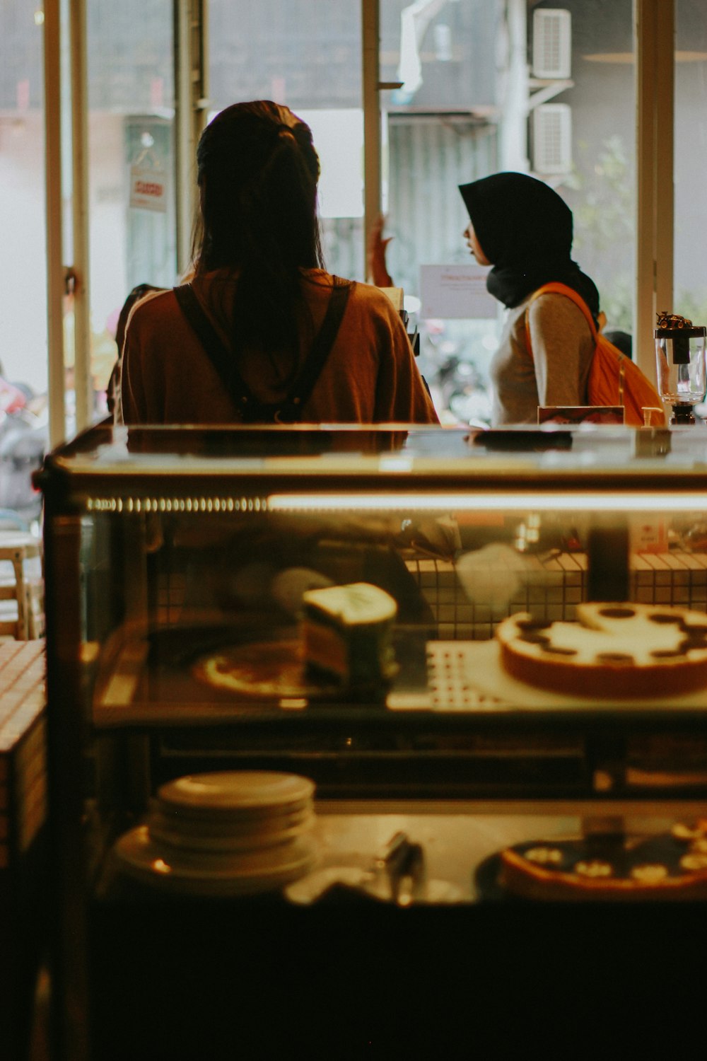 two women sitting at a counter in a bakery