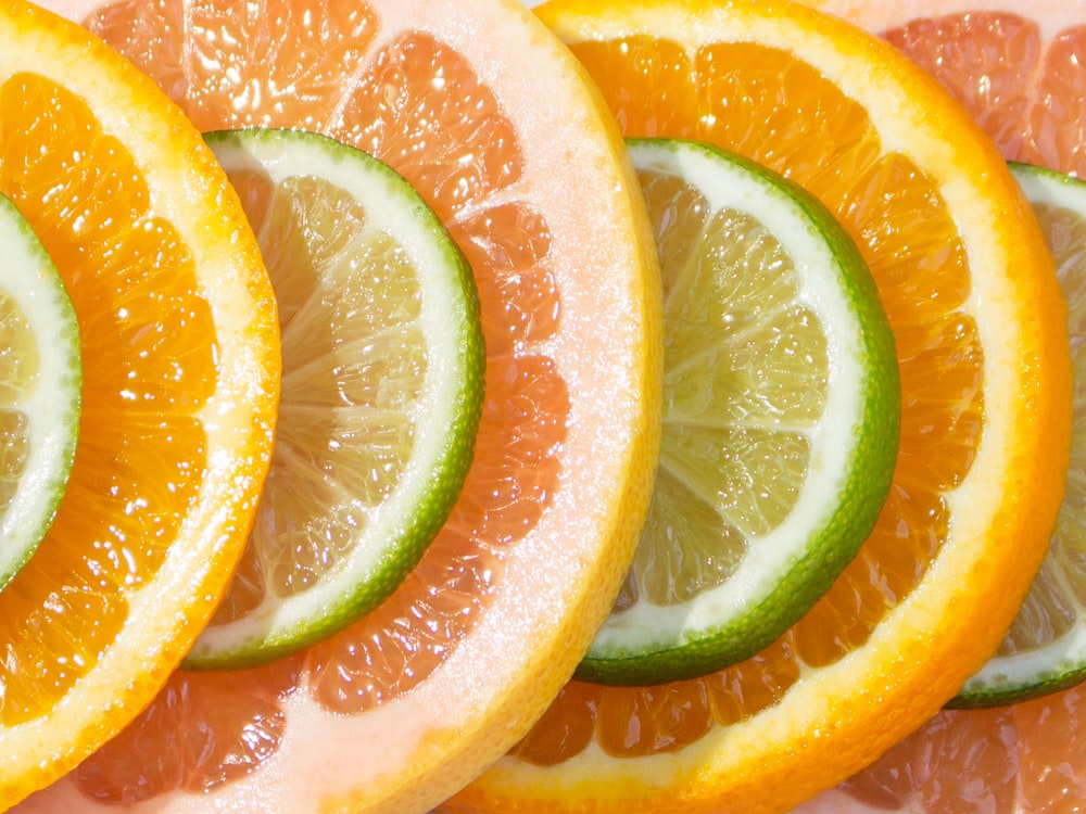 a group of oranges and limes cut in half