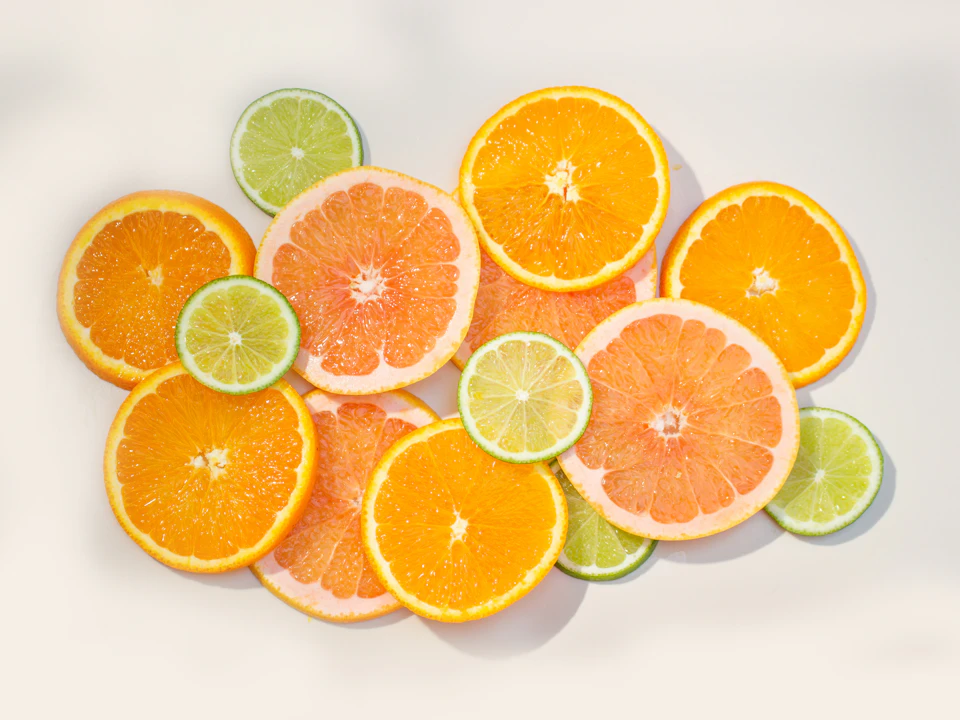 Vibrant citrus fruits arranged symmetrically on a white background with contrasting orange slices