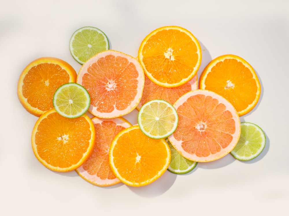 a group of oranges and limes cut in half