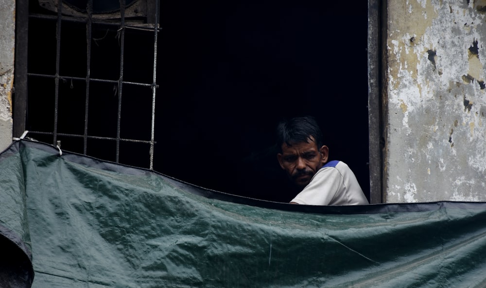 a man is looking out of a window