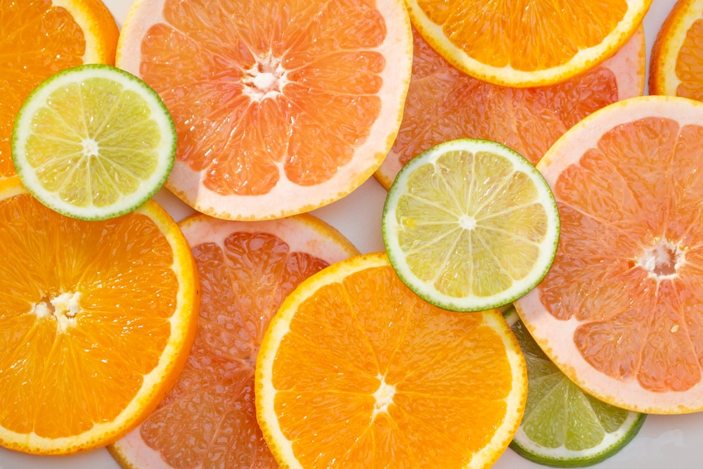 a bunch of oranges and limes cut in half