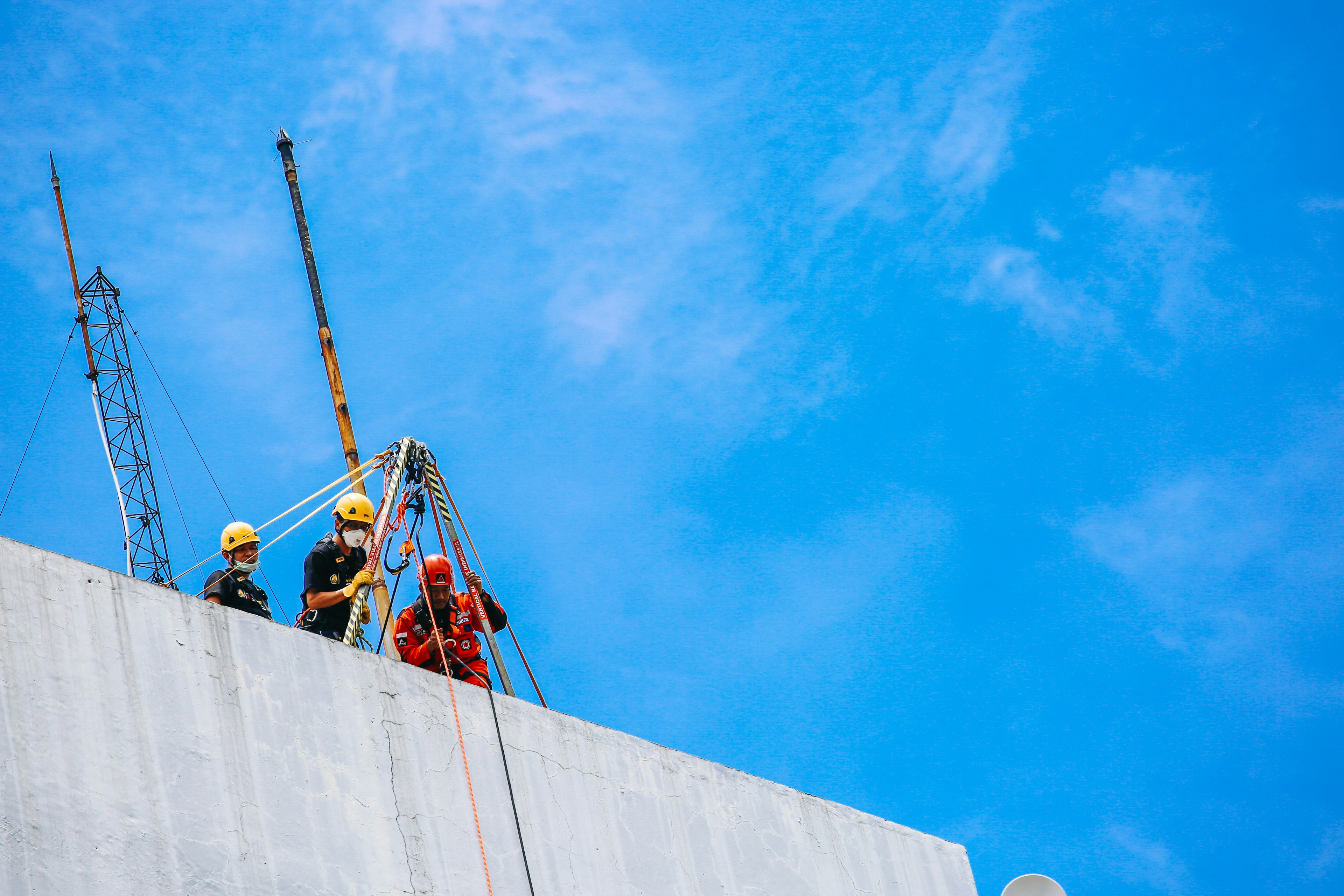a couple of men standing on top of a cement wall