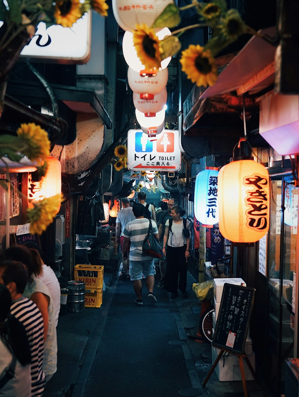 a group of people walking down a narrow street