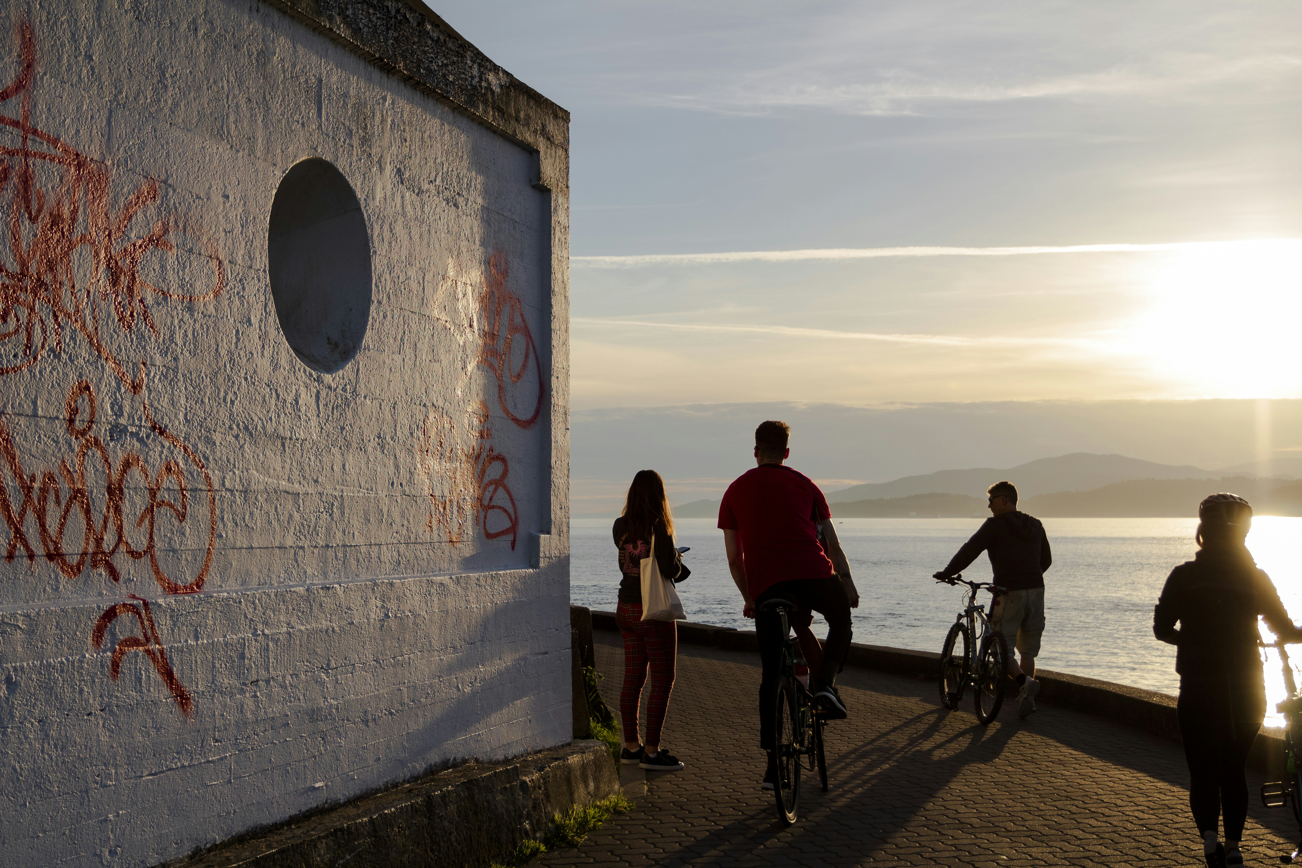 Un grupo de personas montando en bicicleta junto a un cuerpo de agua