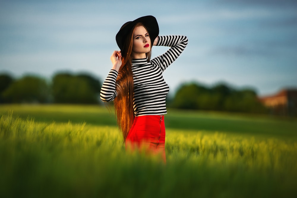 a woman with long hair standing in a field