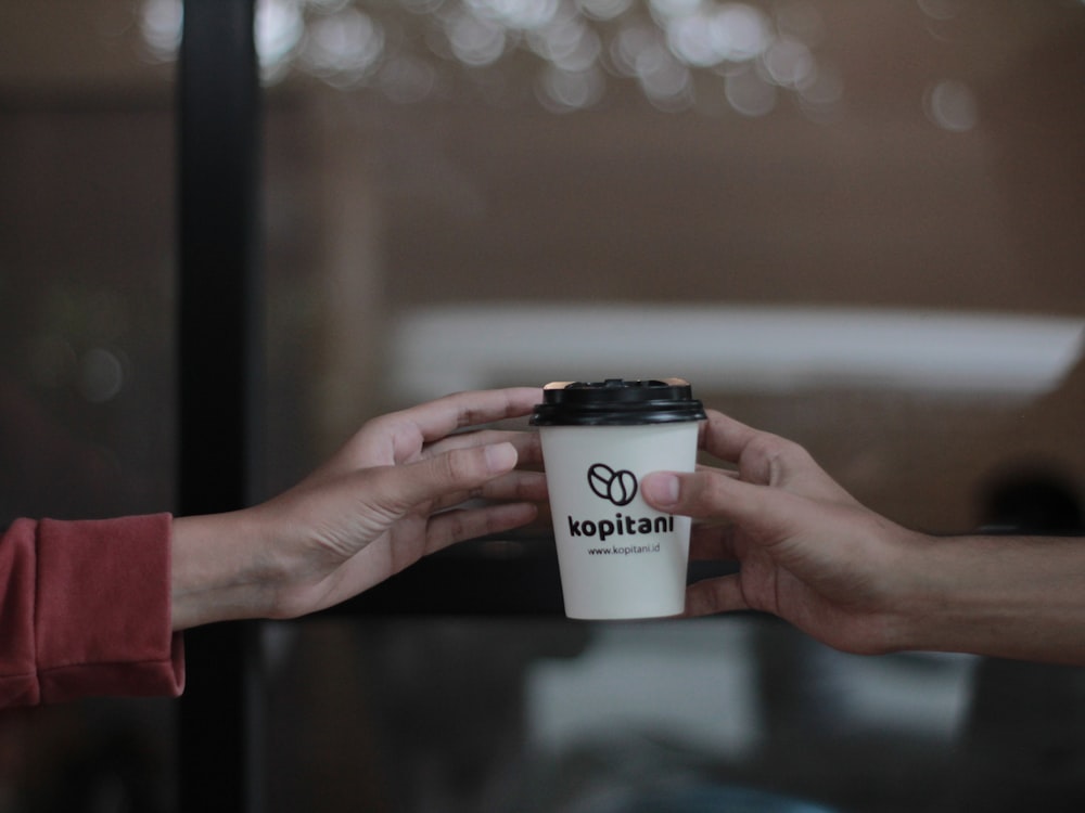 a person holding a cup of coffee in their hands