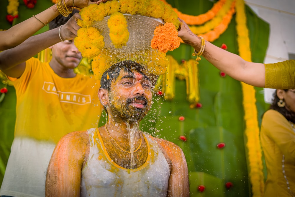 a man is covered in orange and yellow water