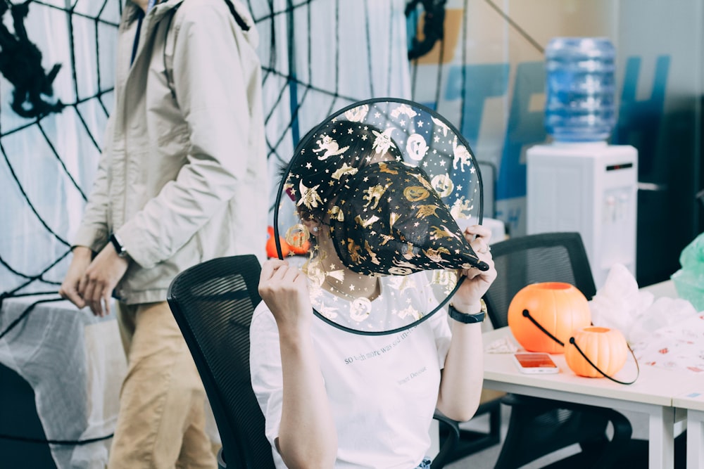 a person sitting in a chair with a hat on their head