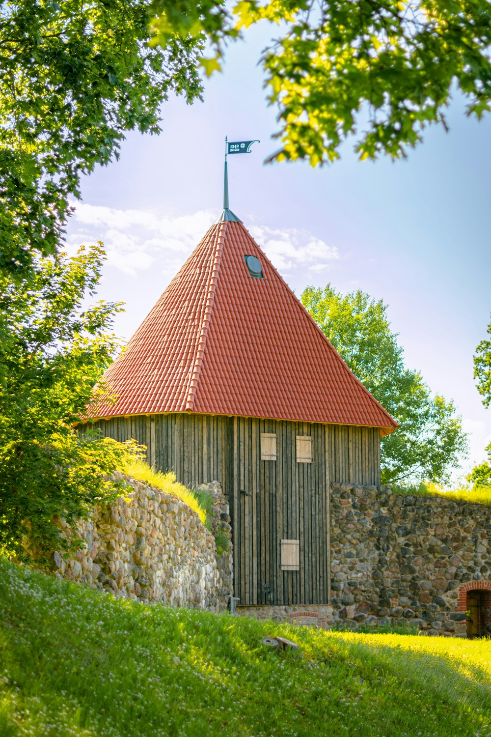 a small building with a red roof and a flag on top of it