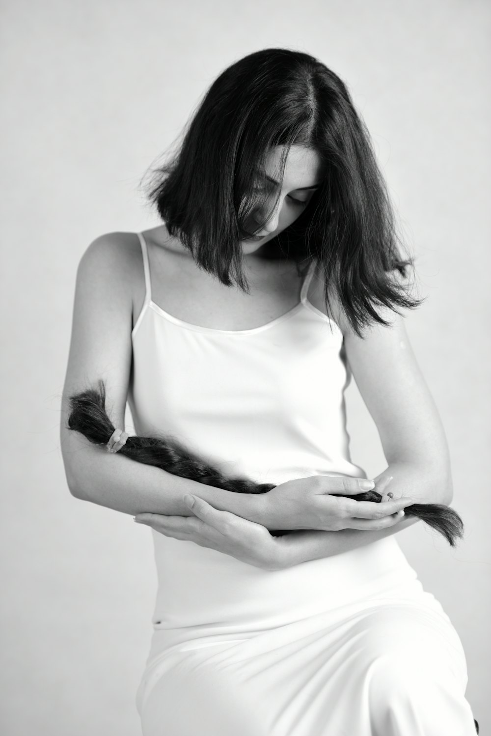 a black and white photo of a woman holding a cat