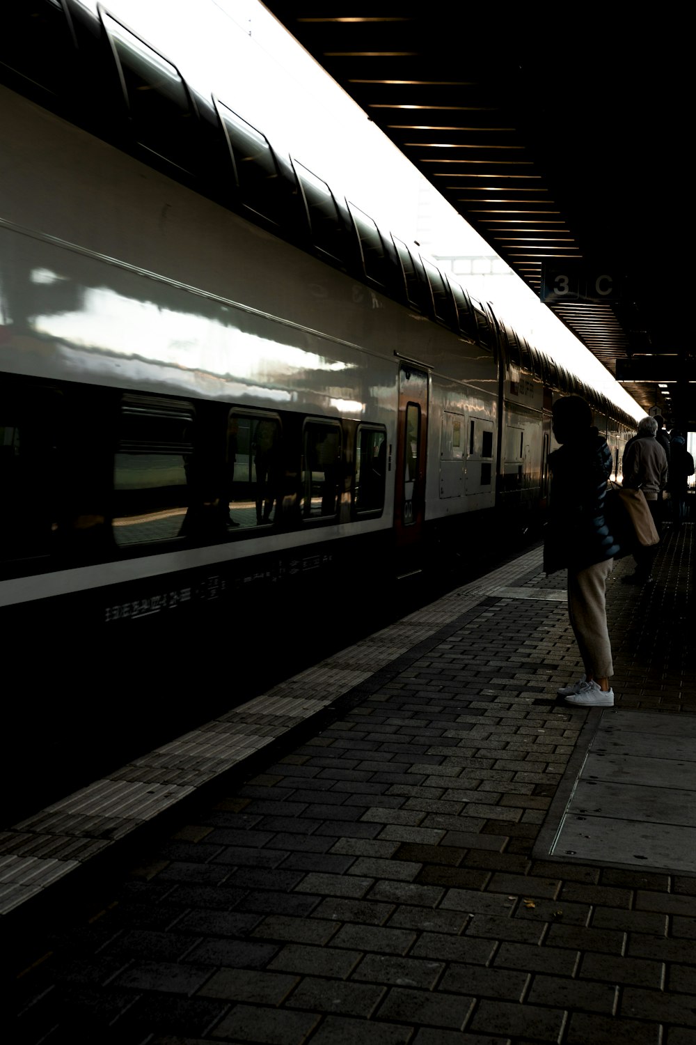a person standing next to a train at a train station