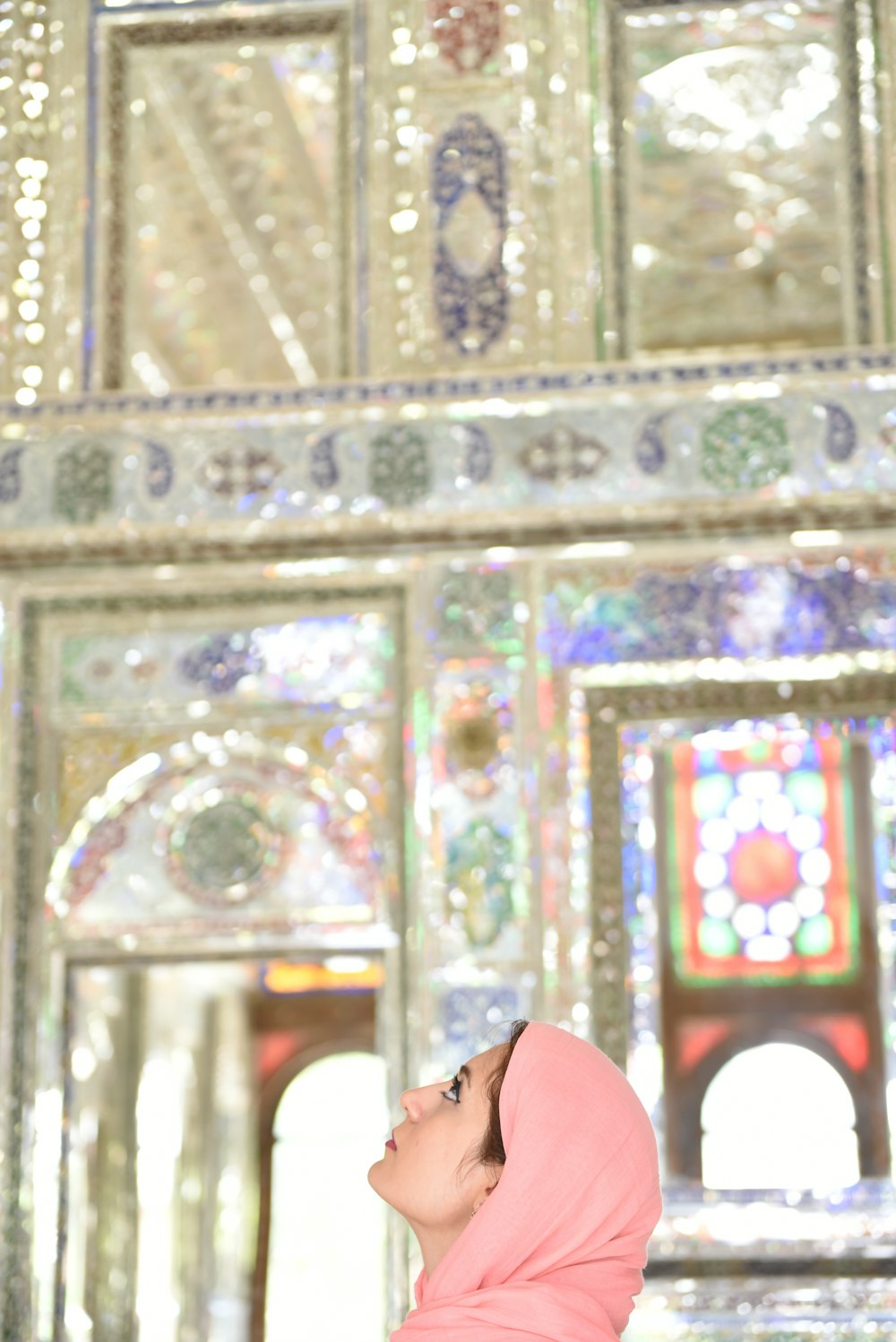 a woman in a pink hijab looking up at the ceiling
