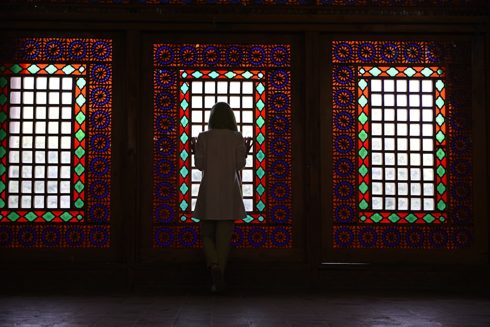 a woman standing in front of a stained glass window