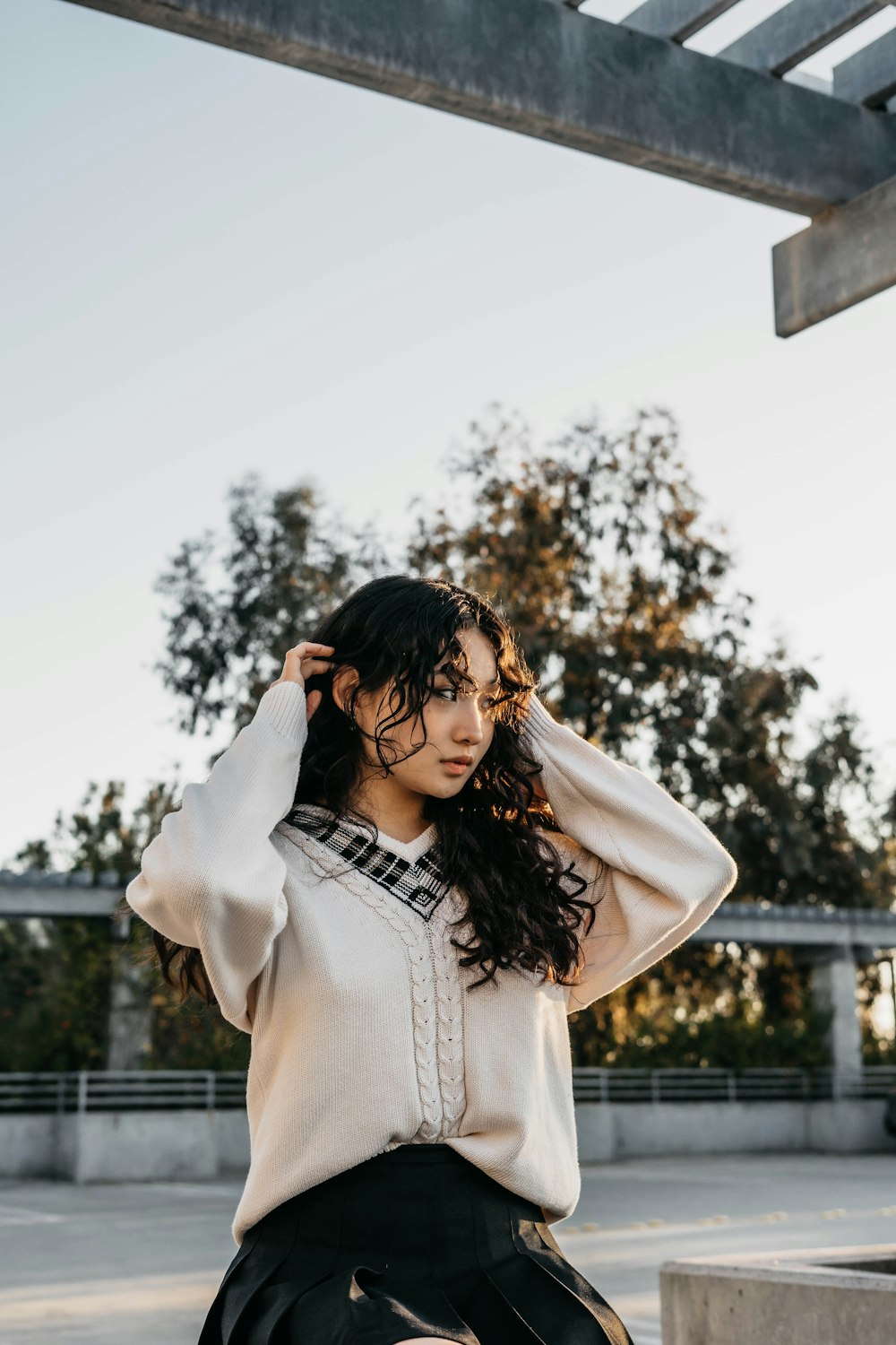 a woman sitting on a bench wearing a sweater