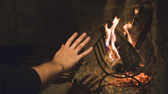 Members warming up by a crackling fire inside a rustic lodge.
