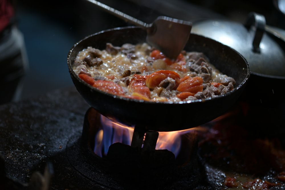 a skillet of food cooking on a stove