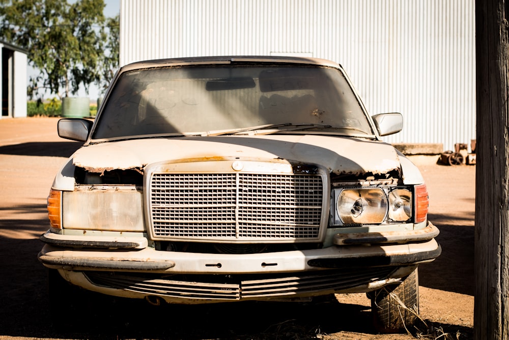 a dirty truck parked in front of a building